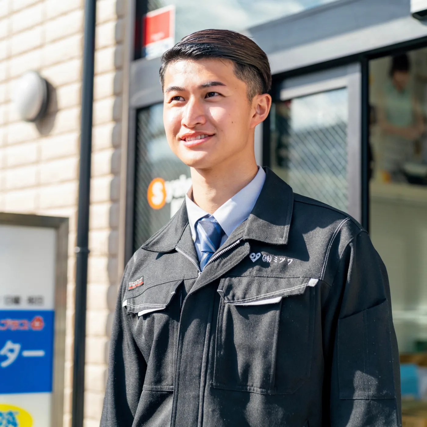 スタッフが事務所を背景に正面を見ている写真